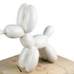 Weiße Ballonhunde-Skulptur auf Holzsockel.